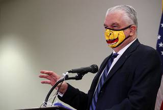 Gov. Steve Sisolak speaks during a news conference at the Grant Sawyer State Building in Las Vegas Sept. 29, 2020. The governor provided updates on Nevadas COVID-19 response efforts and adjustments to current capacity limits on gatherings. The face mask is themed after the Golden Knights' mascot Chance the Golden Gila Monster.