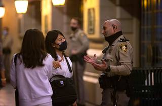 A Paris Las Vegas security officer talks with women at a casino entrance after a temporary power outage at the Paris Las Vegas Thursday, Oct. 22, 2020. The outage forced the evacuation of guests.
