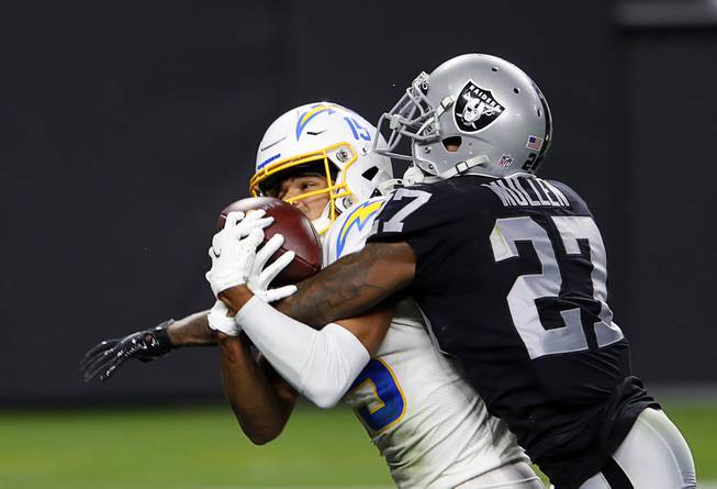 Los Angeles Chargers wide receiver Jalen Guyton (15) tries to hold onto a pass as he is covered by Las Vegas Raiders cornerback Trayvon Mullen (27) during the second half of a game at Allegiant Stadium Thursday, Dec. 17, 2020. The pass was ruled incomplete.