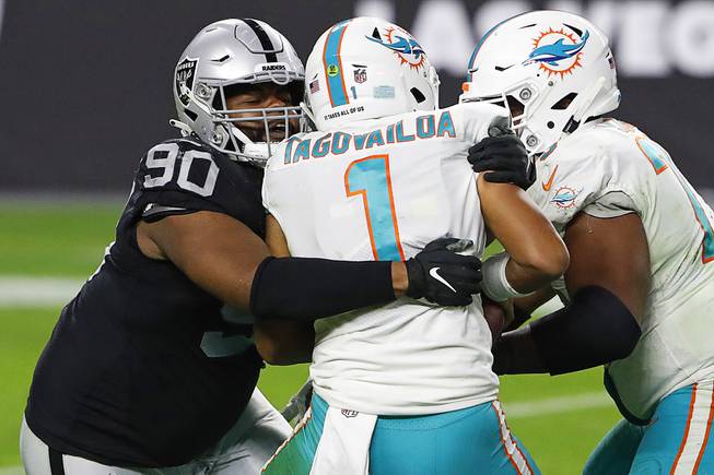 Las Vegas Raiders defensive tackle Johnathan Hankins (90) sacks Miami Dolphins quarterback Tua Tagovailoa (1) during the second half of an NFL football game, Saturday, Dec. 26, 2020, in Las Vegas.