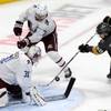 The puck bounces away from Vegas Golden Knights center Chandler Stephenson (20) as Colorado Avalanche defenseman Devon Toews (7) and Avalanche goaltender Philipp Grubauer (31) defend during the second period of an NHL hockey game in Denver, Saturday, March 27, 2021.