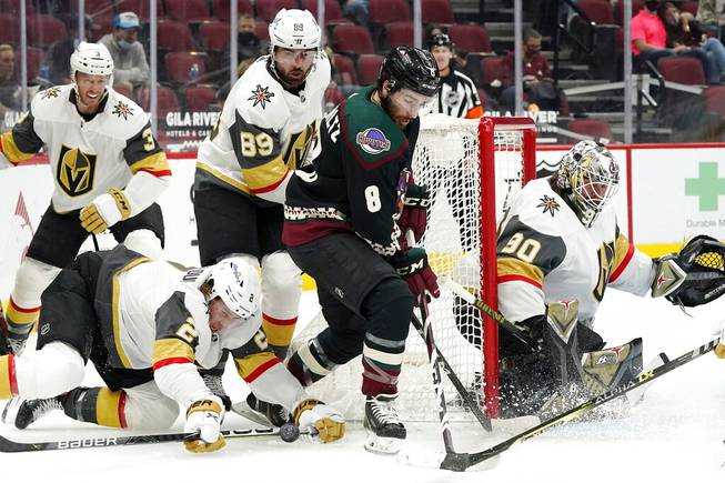 Arizona Coyotes center Nick Schmaltz (8) loses the puck as he tries to skate past Vegas Golden Knights defenseman Zach Whitecloud (2) and right wing Alex Tuch (89) as defenseman Brayden McNabb (3) and goaltender Robin Lehner (90) look on during the first period of an NHL hockey game Friday, April 30, 2021, in Glendale, Ariz. 
