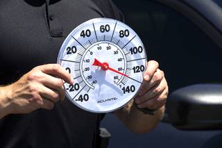 Metro Police Officer Larry Hadfield holds a thermometer during a news conference at Metro Police headquarters Thursday, May 13, 2021. Hadfield was in a car as the temperature went from 85 degrees Fahrenheit to over 130 degrees in about 10 minutes.