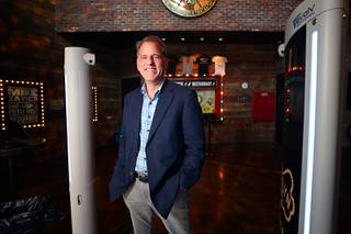 Mike Ellenbogen, founder and chief innovation officer for Evolv Technology, poses with an Evolv Express security screener at the entrance to the Brooklyn Bowl in the Linq Promenade Tuesday, July 20, 2021. The screener uses magnetic field signatures and artificial intelligence to detect weapons while ignoring metal objects such as phones or keys.