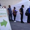 In this Wednesday, July 7, 2021, file photo, people wait in line for COVID-19 vaccinations at an event at La Bonita market, a Hispanic grocery store, in Las Vegas. In this Wednesday, July 7, 2021, file photo, people wait in line for COVID-19 vaccinations at an event at La Bonita market, a Hispanic grocery store, in Las Vegas.