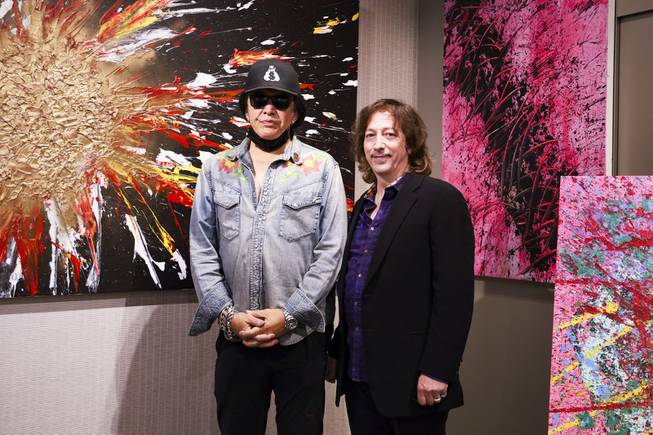 KISS singer and musician, Gene Simmons, left, and Nicholas Leone, owner and CEO of Animazing Gallery, right, pose for a photo next to Simmons' painting currently on display at the gallery, Thursday, Aug. 5, 2021. The pieces in Gene Simmons ArtWorks will be publicly debuted from Oct. 14 to 16, with a private opening-day reception and two days of public presentations. YASMINA CHAVEZ