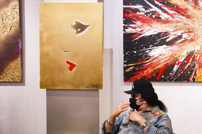 Paintings by KISS singer and musician, Gene Simmons, are seen in the background as he's interviewed at Animazing Gallery inside the Grand Canal Shoppes at the Venetian, Thursday, Aug. 5, 2021. The pieces in Gene Simmons ArtWorks will be publicly debuted from Oct. 14 to 16, with a private opening-day reception and two days of public presentations. YASMINA CHAVEZ