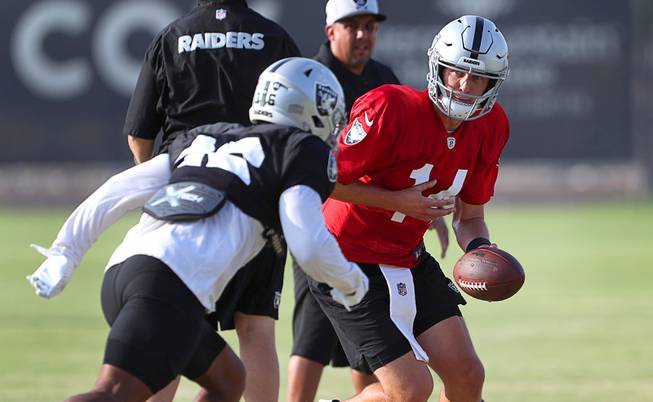 Las Vegas Raiders quarterback Case Cookus (14) hands the ball off to wide receiver Dillon Stoner (16) during Raiders Training Camp at the Intermountain Healthcare Performance Center in Henderson Thursday, Aug. 12, 2021.