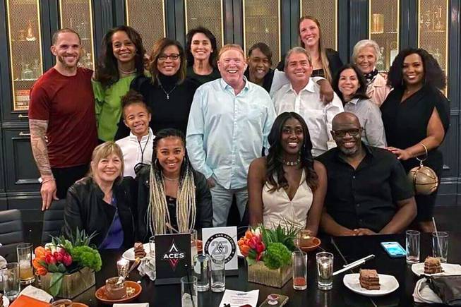 This photo provided by Sylvia Crawley Spann, shows former WNBA player Sylvia Crawley Spann and her husband, Brian, seated bottom right, celebrating their wedding with Las Vegas Aces WNBA basketball team owner Mark Davis, standing at center, and other former members of the franchise and their guests at a restaurant in Las Vegas on May 29, 2021.