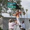 From left, Clark County Commissioner Tick Segerblom, former County Commissioner Chris Giunchigliani and neighborhood organizer Dave Cornoyer unveil a street sign topper during an event in the historic Paradise Palms neighborhood Wednesday, Sept. 1, 2021.