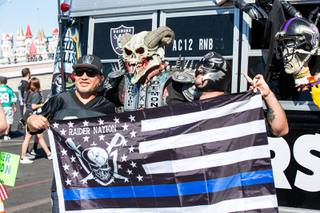 Raiders fans pose for a photo with Darkside Demon in front of Allegiant Stadium before the Las Vegas Raiders's first home game of the season against the Baltimore Ravens, Monday Sept. 13, 2021. This is the first game with fans attending.