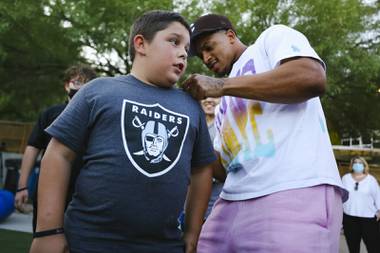 Las Vegas Raiders defensive back Johnathan Abram signs young fan Jacob’s shirt during a Big Brothers Big Sisters of Southern Nevada shoe giveaway at Springs Preserve Tuesday, Sept. 14, 2021.
