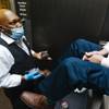 Photo: Keith Bryant shines Christopher Helmick's shoes at Photo: Keith Bryant shines Christopher Helmick's shoes at
