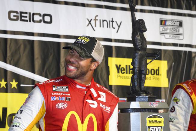 Bubba Wallace celebrates next to the trophy after winning a NASCAR Cup series auto race Monday, Oct. 4, 2021, in Talladega, Ala. The race was stopped mid-race due to rain.