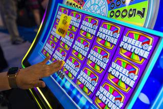An attendee plays a new Wheel of Fortune video slot machine at the IGT booth during the Global Gaming Expo (G2E) at the Sands Expo Center Tuesday, Oct. 5, 2021.
