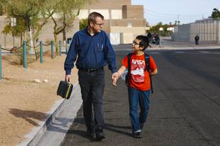 Lenny Lither and his son Octavian Lither, 11, walk to their car from Walter Johnson Junior High School Wednesday, Oct. 6, 2021.
