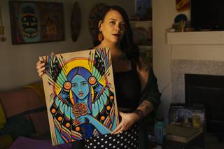 Steph Littlebird poses for a photo with their painting titled Goddess of the Blossoms Wednesday, Nov. 3, 2021.