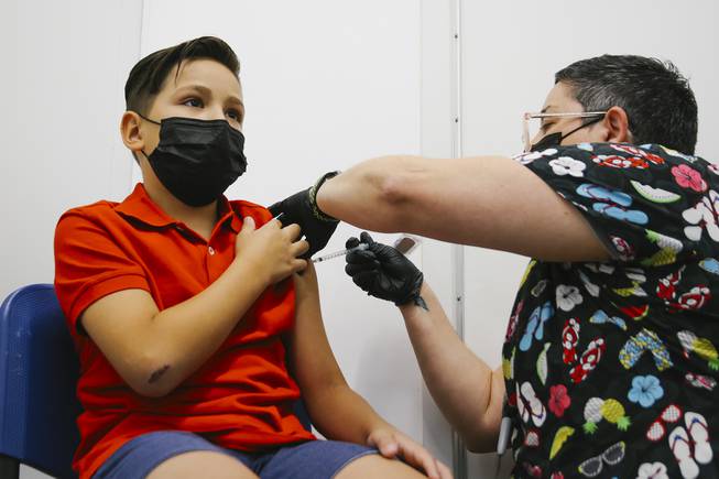 Dario Alonso, 10, receives a Pfizer COVID-19 vaccination from registered nurse KJ Dionisio at the Southern Nevada Health District Wednesday, Nov. 10, 2021.