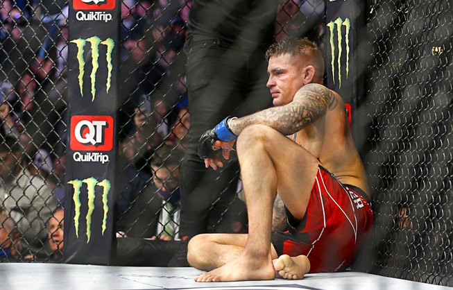 Dustin Poirier sits after losing via submission to Charles Oliveira in a lightweight mixed martial arts title bout at UFC 269, Saturday, Dec. 11, 2021, in Las Vegas.