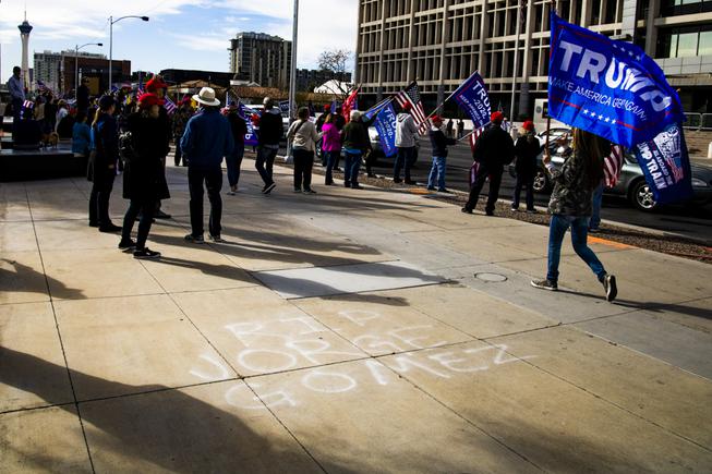 Supporters of President Donald Trump gather around a "R.I.P. Jorge Gomez" message on the sidewalk in front of the Lloyd D George Courthouse in downtown Las Vegas during a "Stop the Steal" protest and car parade Wed., Jan. 6, 2021. Gomez was killed in an altercation with police in front of the George Federal Building during a BLM protest on June 1, 2020. YASMINA CHAVEZ