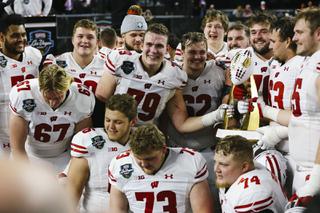 The Wisconsin Badgers celebrate and hold the championship trophy after defeating the Arizona State Sun Devils, 20-13, in the SRS Distribution Las Vegas Bowl game at Allegiant Stadium Thursday, Dec. 30, 2021.