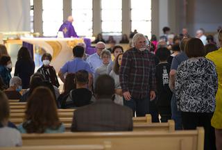 Members of the congregation line up to donate to Ukrainian charities during a special Mass for Ukraine at the Holy Spirit Catholic Church Sunday, March 13, 2022.
