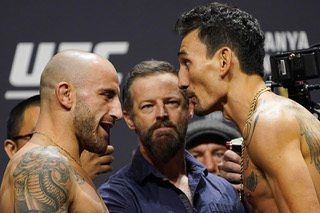 Alexander Volkanovski, left, and Max Holloway face off during a ceremonial weigh-in for the UFC 276 mixed martial arts event, Friday, July 1, 2022, in Las Vegas. The two are scheduled to fight in a featherweight title bout Saturday in Las Vegas.