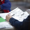 Photo: Election workers inspect mail-in ballots in the co
