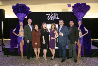 Showgirls Tara Taylor, left and Jennifer Autry flank Hospitality Heroes winners during a 2022 Hospitality Heroes reception in the West Hall of the Las Vegas Convention Center Thursday, Dec. 15, 2022. Also pictured are Steve Hill, second left, president/CEO of the Las Vegas Convention and Visitors Authority, and Peter Guzman, third right, president/CEO of the Latin Chamber of Commerce. Winners from left are: Candace Ortiz, NoMad, Ericka Stokely, Resorts World Las Vegas, Paola Crow, The Cosmopolitan, and Keoki Hill, Planet Hollywood.