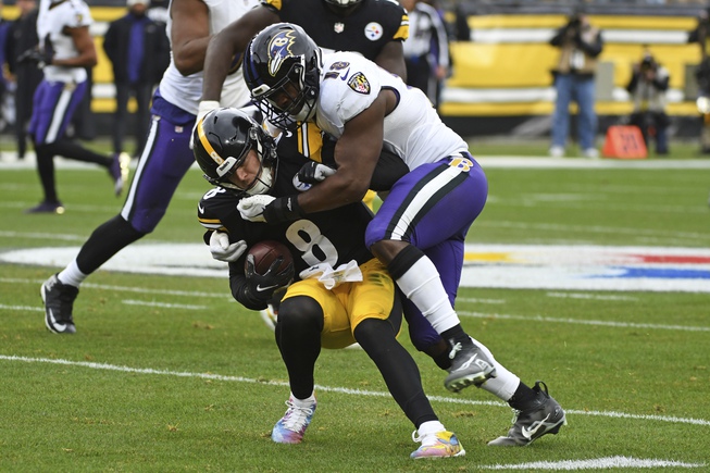 Pittsburgh Steelers quarterback Kenny Pickett (8) is tackled by Baltimore Ravens linebacker Roquan Smith (18) during the first half of an NFL football game in Pittsburgh, Sunday, Dec. 11, 2022.


