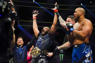 Jon Jones celebrates in the octagon at T-Mobile Arena after defeating Ciryl Gane via submission in the first round of the UFC 285 main event to win the heavyweight championship.