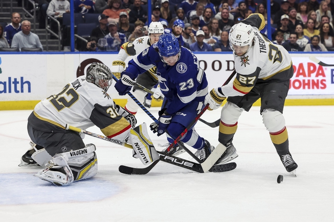 Vegas Golden Knights' Shea Theodore (27) checks Tampa Bay Lightning's Michael Eyssimont (23) in front of goaltender Jonathan Quick during the second period Thursday, March 9, 2023, in Tampa, Fla. 


