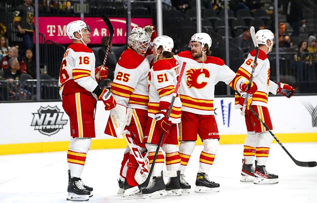 Calgary Flames players celebrate with goaltender Jacob Markstrom (25) after beating the Vegas Golden Knights , 7-2, in an NHL hockey game at T-Mobile Arena Thursday, March 16, 2023.
