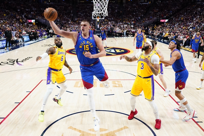 Denver Nuggets center Nikola Jokic (15) pulls down a rebound as Los Angeles Lakers forward Anthony Davis (3) looks on during the first half of Game 1 of the NBA basketball Western Conference Finals series, Tuesday, May 16, 2023, in Denver. 


