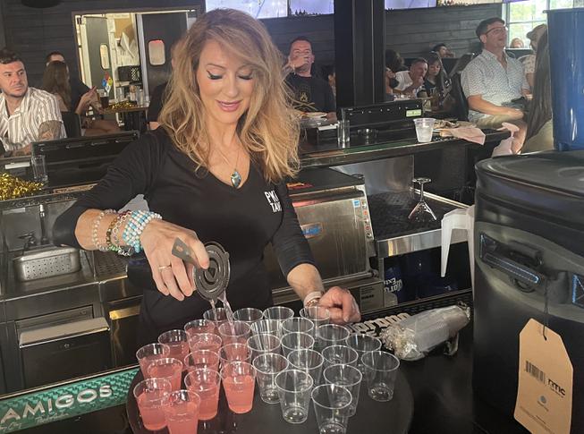 Allyse Tyson, of Las Vegas, pours free shots after a goal is made Saturday night at PKWY Tavern Tivoli Village. 