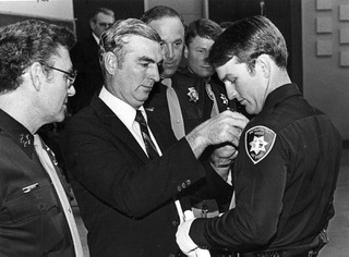 Metro Police Officer Ralph Ray, right, gets his badge pinned by his father Assistant Sheriff Paul Ray at his graduation in 1981. Sheriff John McCarthy, left, and Sgt. Richard McKee look on. From the Las Vegas Sun Archive. Don Ploke/Las Vegas Sun