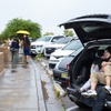 Olivia Qi and Sean Liu, of Mountain View Calif., look over Red Rock Canyon from the shelter of their SUV as light rain falls at the Red Rock Overlook Saturday, Aug. 19, 2023.