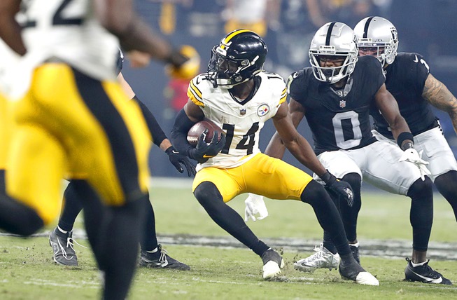 Pittsburgh Steelers wide receiver George Pickens (14) carries the ball ahead of Las Vegas Raiders cornerback Jakorian Bennett (0) during the second half of an NFL football game at Allegiant Stadium Sunday, Sept. 24, 2023.
