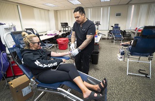 Vitalant phlebotomist Ivan Puzon assists Mynda Smith, sister of Neysa Tonks, during a blood drive at the Clark County Government Center Thursday, Sept. 28, 2023. Tonks was one of the victims of the Oct. 1, 2017 mass shooting.