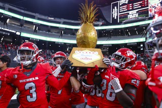 UNLV Rebels players hold up the 9th Island Showdown trophy after defeating the Hawaii Warriors, 44-20, during an NCAA college football game at Allegiant Stadium Saturday, Sep. 30, 2023.