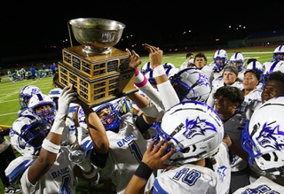 Basic quarterback Anthony Vega (1) holds up the Henderson Bowl trophy after Basic defeated Green Valley 19-17 at Green Valley High School Friday, Oct. 13, 2023, in Henderson.
