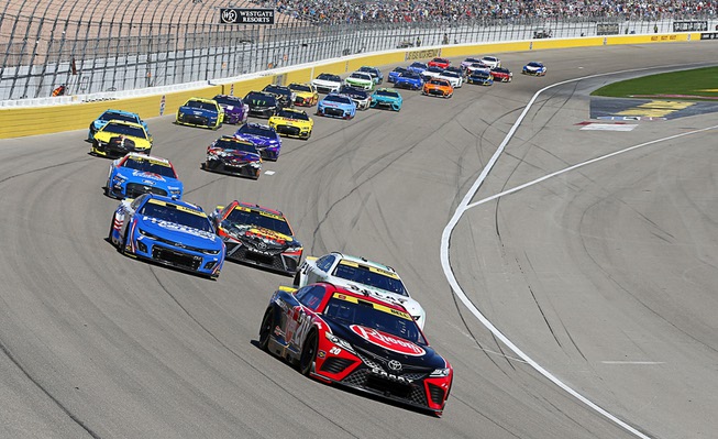 Christopher Bell (20) leads drivers into turn one during the South Point 400 NASCAR Cup Series auto race at the Las Vegas Motor Speedway Sunday, Oct. 15, 2023.