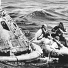 Apollo 16 astronauts, from left wearing white suits, Thomas Kenneth Mattingly, John Young and Charles Duke, pose for photographs by Navy Frogmen in rubber raft after leaving spaceship, left, in the Pacific Ocean on April 27, 1972. Mattingly, an astronaut who is best remembered for his efforts on the ground that helped bring the damaged Apollo 13 spacecraft safely back to Earth, has died Tuesday, Oct. 31, 2023, NASA announced.