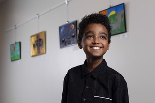 Isaiah Norris, 9, poses for a photo in front of his paintings at the Winchester Cultural Center Tuesday, Dec. 5, 2023.