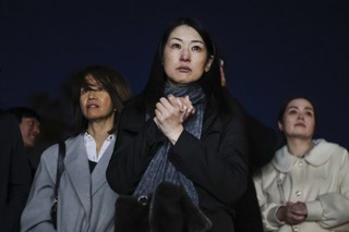 Mayumi Hirano mourns at the home of her supervisor Naoko Takemaru's home during a vigil Saturday, Dec. 9, 2023. Takemaru, a Japanese studies professor, was killed along with two other professors Wednesday by a gunman at the University of Nevada, Las Vegas.