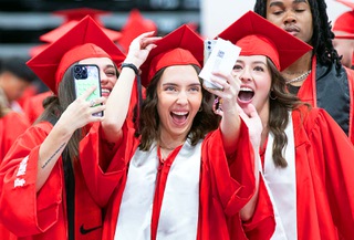 College of Business graduates, from left, Olivia Stabile, Sofia DiChristopher, and Maddie Montano, reacts as they appear on the big screen during a UNLV Winter commencement ceremony at the Thomas & Mack Center Tuesday, Dec. 19, 2023.