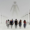 Burning Man participants walk through dust at the annual Burning Man event on the Black Rock Desert of Gerlach, Nev., on Friday, Aug. 29, 2014. 