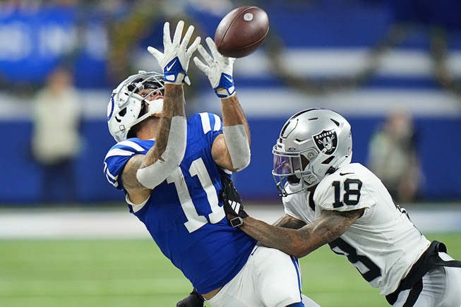 Indianapolis Colts wide receiver Michael Pittman Jr. (11) misses on a catch attempt next to Las Vegas Raiders cornerback Jack Jones (18) during the second half of an NFL football game Sunday, Dec. 31, 2023, in Indianapolis. (AP Photo/AJ Mast)