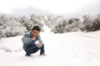 Zee Jaydi, 5, makes a snowball in Mountain Springs, Nevada Wednesday, Jan. 3, 2024.