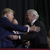Republican presidential candidate former President Donald Trump, left, and South Carolina Gov Henry McMaster, right, embrace on stage during a campaign event in Manchester, N.H., Saturday, Jan. 20, 2024. Also on stage is South Carolina House Speaker Murrell Smith, far right.